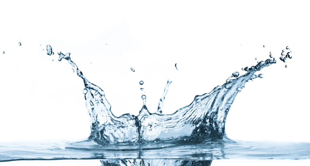 Makrofotografie eines Wassertropfens, der auf Wasser fällt